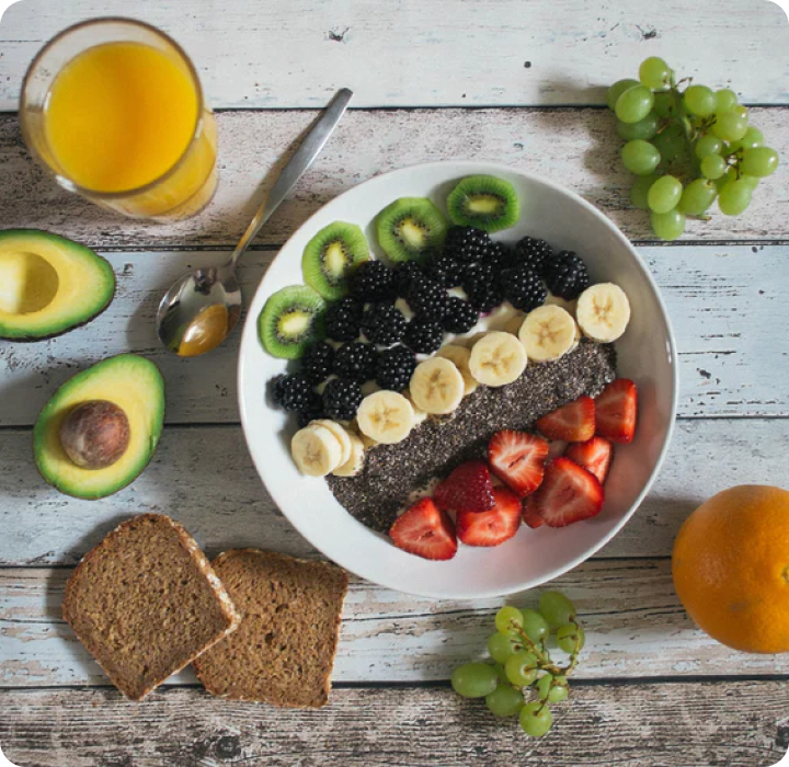 Smoothie bowl with fresh fruit, orange juice and bread
